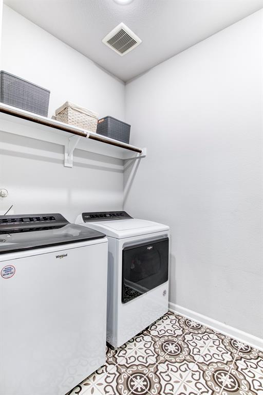 Laundry room with decorative tile flooring.