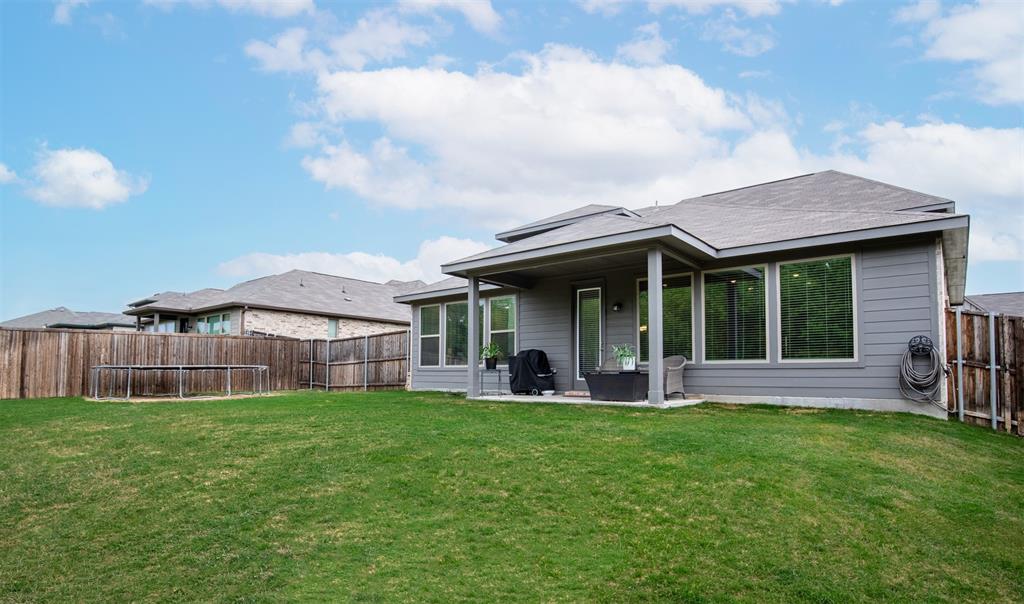 Large grassy yard surrounded by privacy fencing.