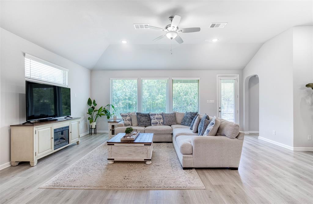 Living room with sloped ceiling and ceiling fan.