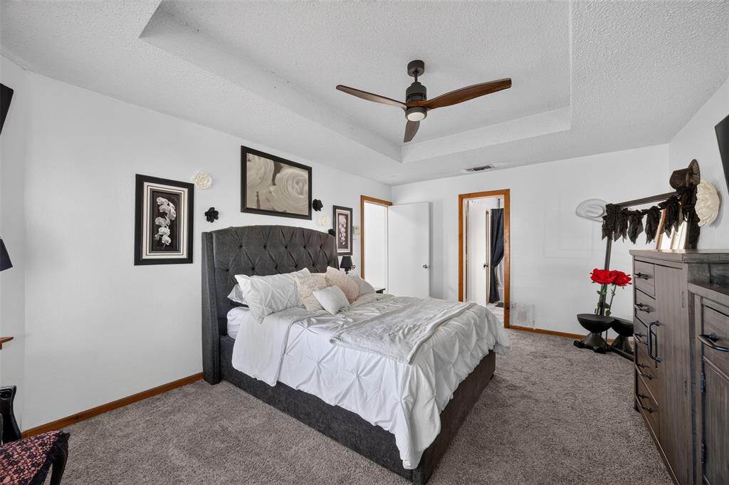 Tray ceiling featuring a dark-finish three-blade ceiling fan with integrated lighting