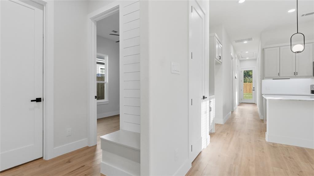 Interior hallway featuring wood-finish flooring, shiplap wall detailing, built-in mudroom bench, recessed lighting, and modern pendant illumination