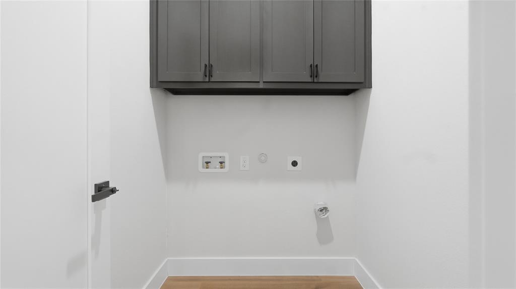 Shaker-style wall cabinetry in a dark finish with matte black hardware, paired with wood-finish flooring