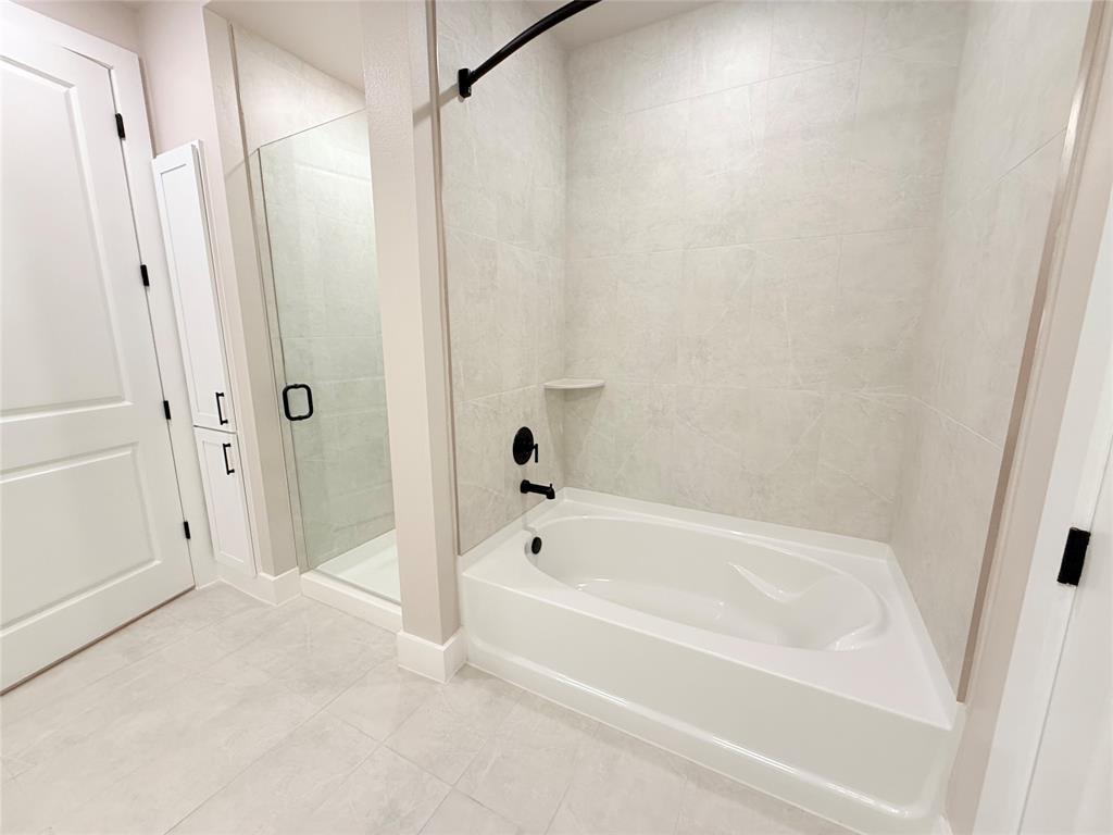 Full bath with a garden tub, a stall shower, and tile patterned flooring