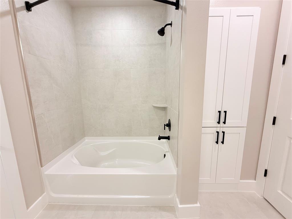 Bathroom featuring shower / bathtub combination and light tile patterned flooring