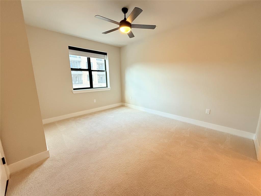 Unfurnished room with light colored carpet and a ceiling fan