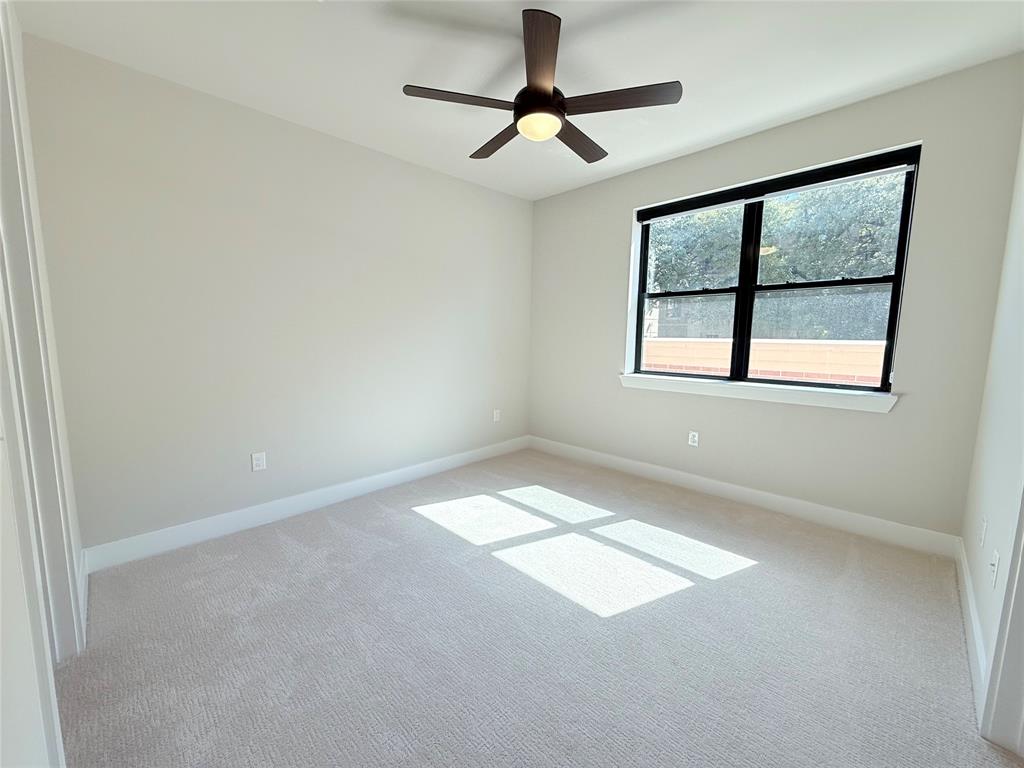Unfurnished room with a ceiling fan and carpet
