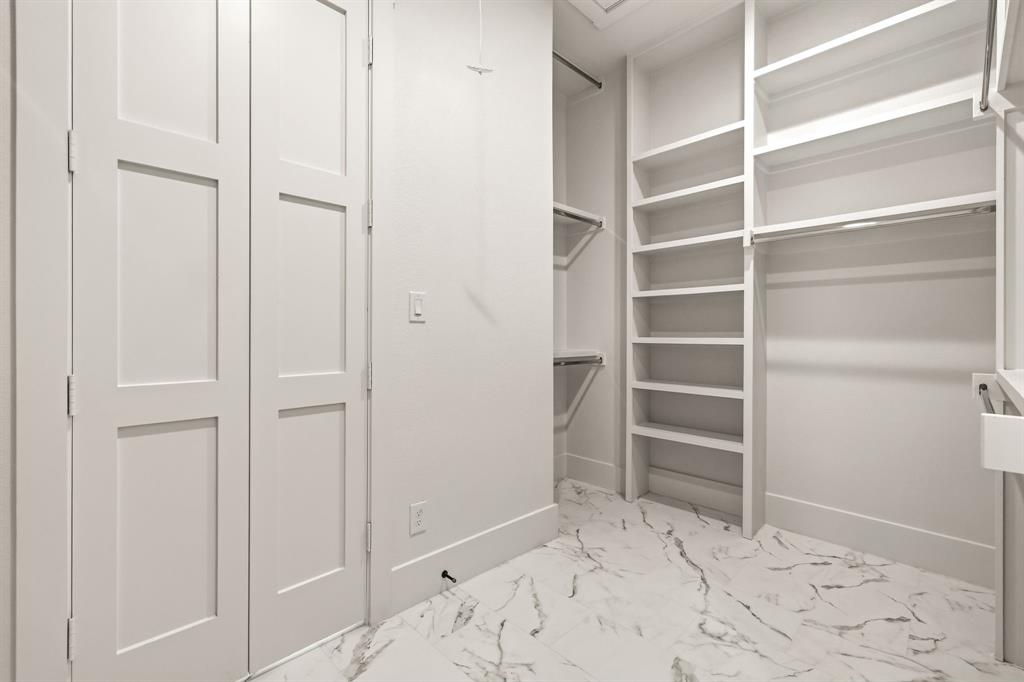 Oversized primary bedroom closet with direct access to laundry room