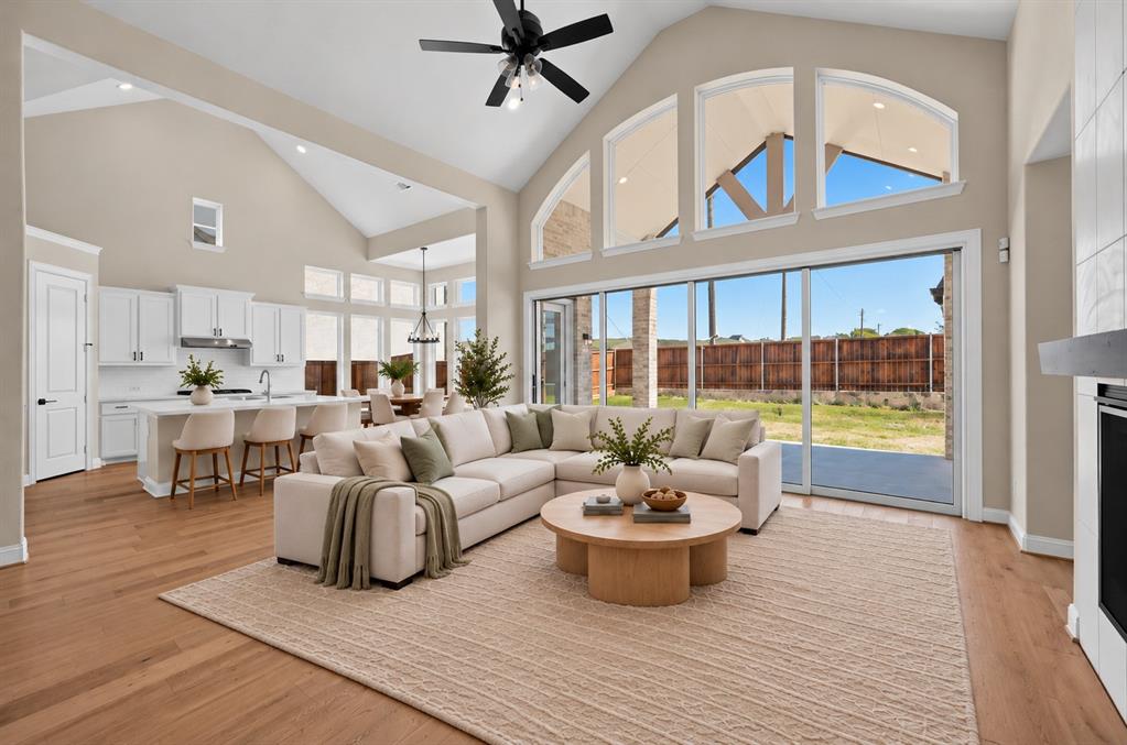 Vaulted ceiling, wood-finish flooring, floor-to-ceiling multi-panel sliding glass doors, arched clerestory windows, and white cabinetry Vaulted ceiling, wood-finish flooring, floor-to-ceiling multi-panel sliding glass doors, arched clerestory windows, and white cabinetry