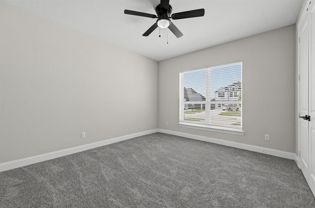 Neutral wall finishes, plush wall-to-wall carpeting, matte black ceiling fan with integrated lighting, and white six-panel closet doors