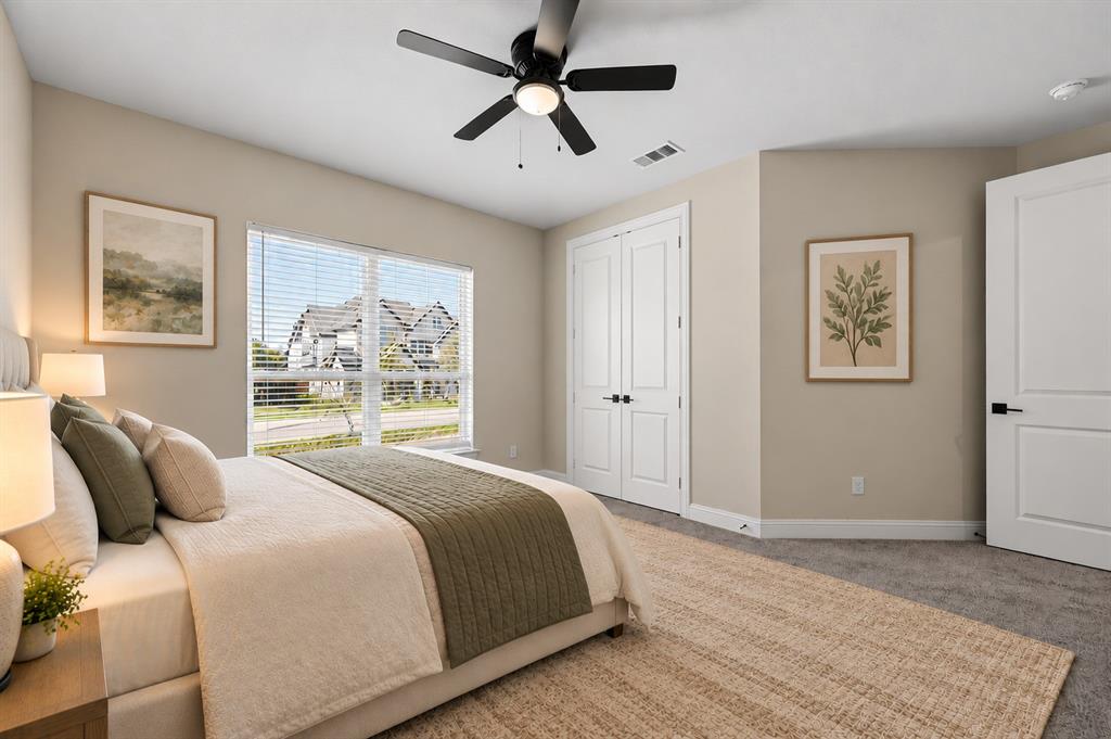 Neutral-toned room featuring a central ceiling fan with an integrated light fixture, double-door closet, multi-pane window, and interior doors with matte black hardware