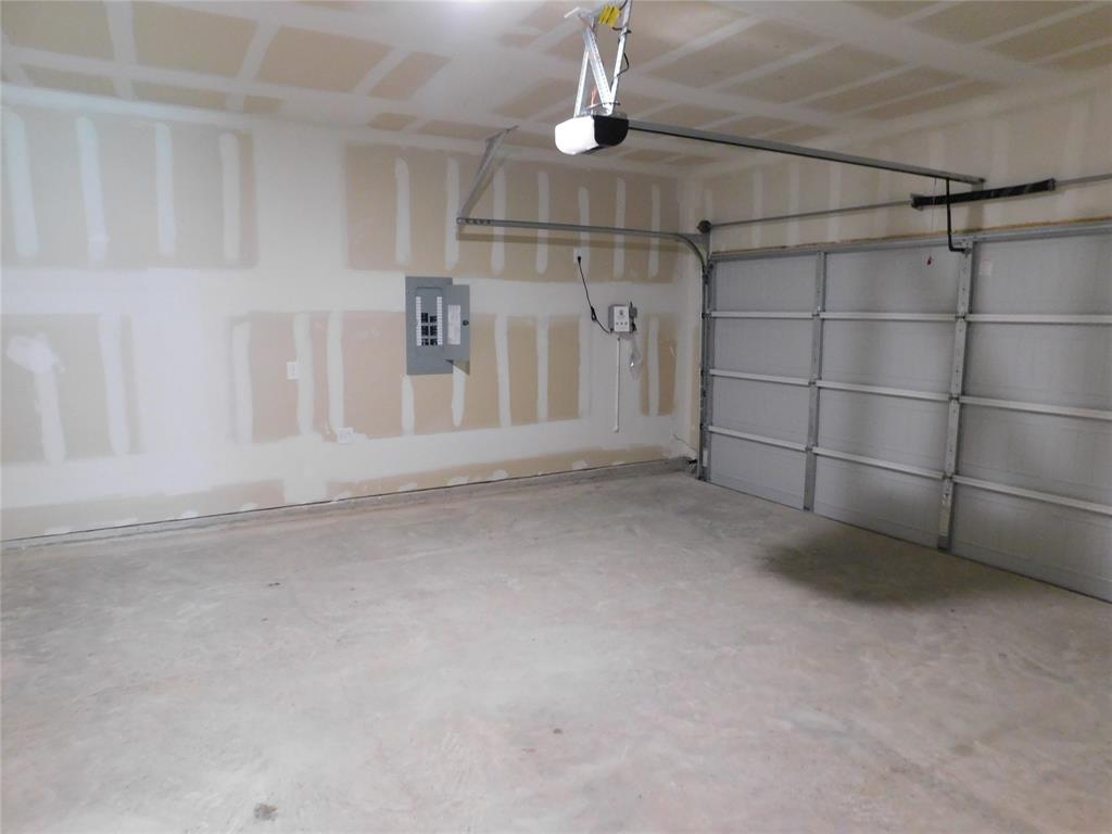 Multi-car garage featuring a concrete floor, sectional overhead garage door, and automatic door opener