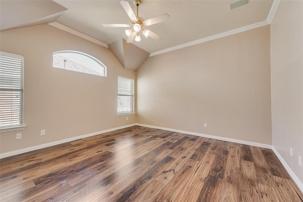 Vaulted ceilings, wood-finish flooring, arched window, and overhead ceiling fan with multi-light fixture