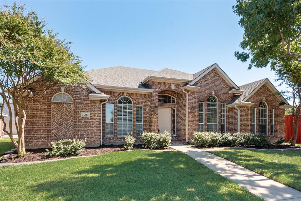 Single-story brick exterior featuring a multi-gabled roofline, arched window detailing, and herringbone masonry accents