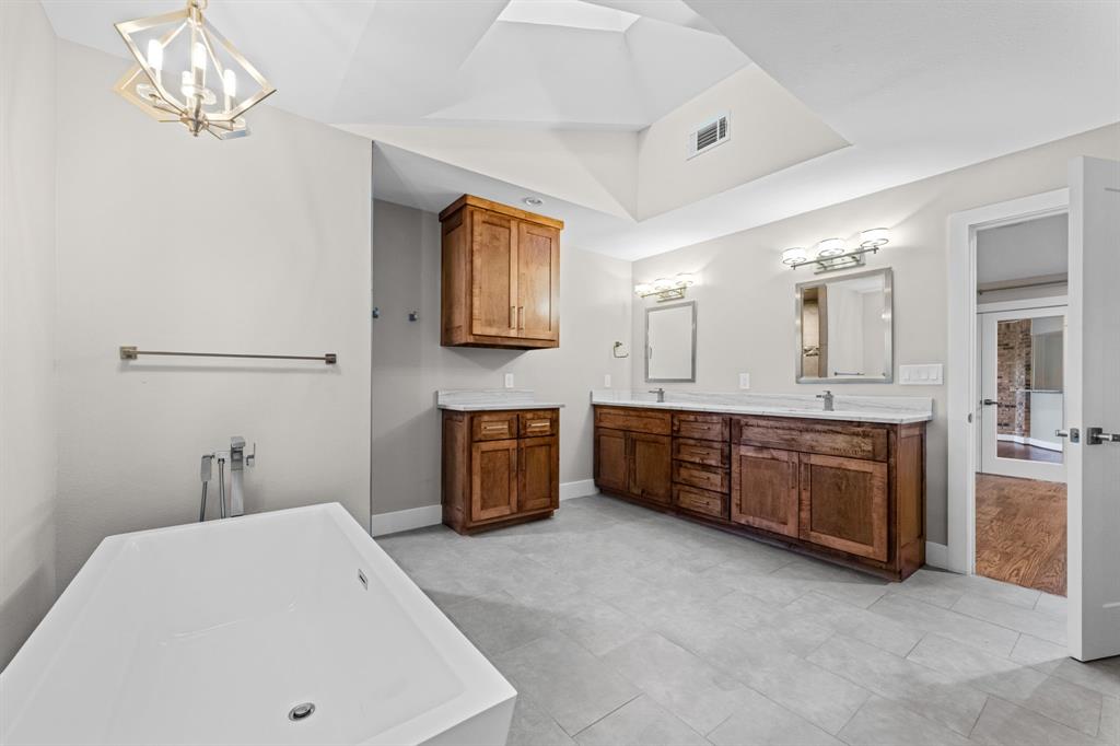 Ensuite primary bathroom features an oversized vanity with 2 sinks and a soaking tub