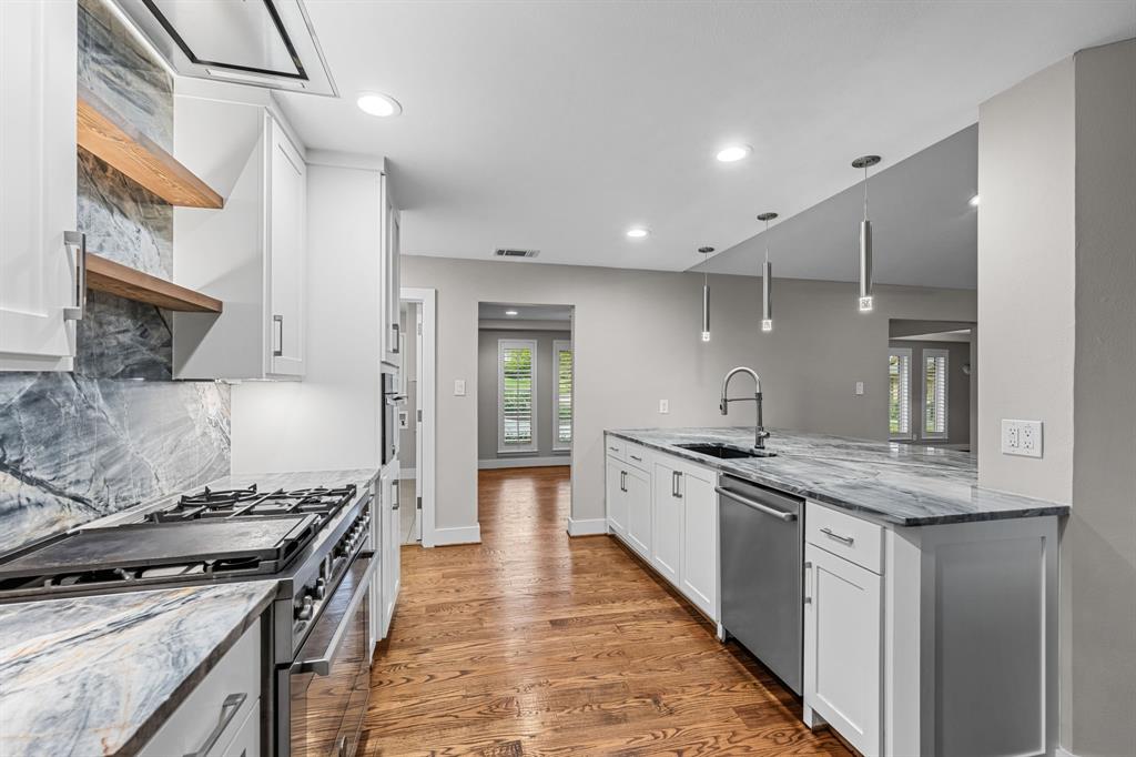 Kitchen featuring white shaker cabinetry is open to the front of the home