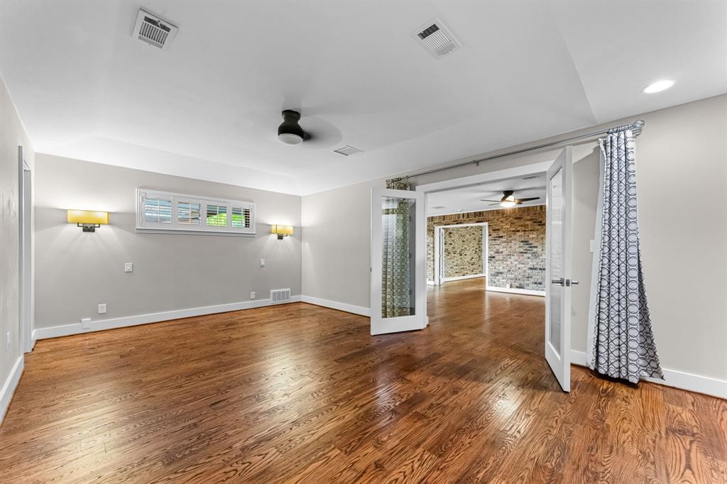 The primary bedroom is off the second living room and features a ceiling fan and sconces