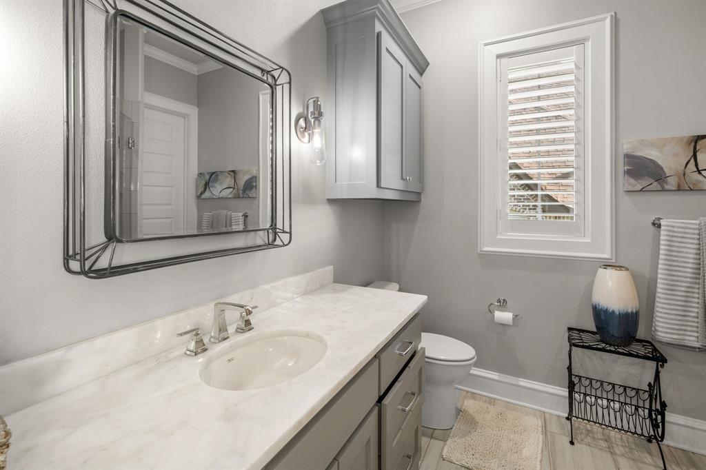 Vanity featuring a light-toned countertop, undermount sink, and wall-mounted metallic light fixture