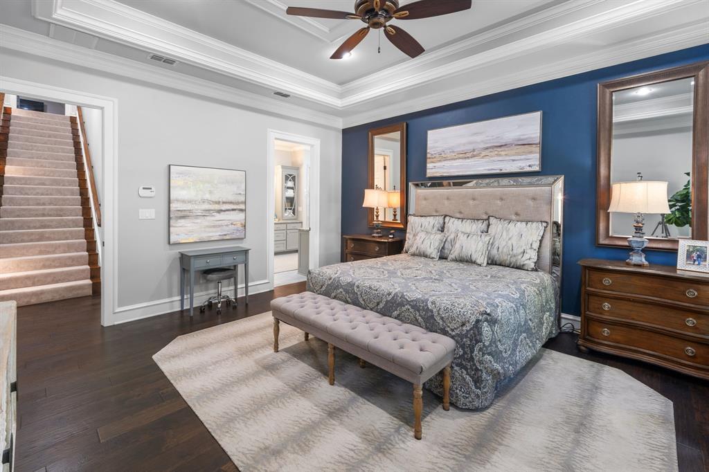 Tray ceiling, dark wood-finish flooring, and a deep blue accent wall