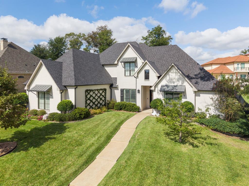 Light-toned brick exterior featuring multiple gables, metal window awnings, a structured wall trellis, and a paved walkway Light-toned brick exterior featuring multiple gables, metal window awnings, a structured wall trellis, and a paved walkway