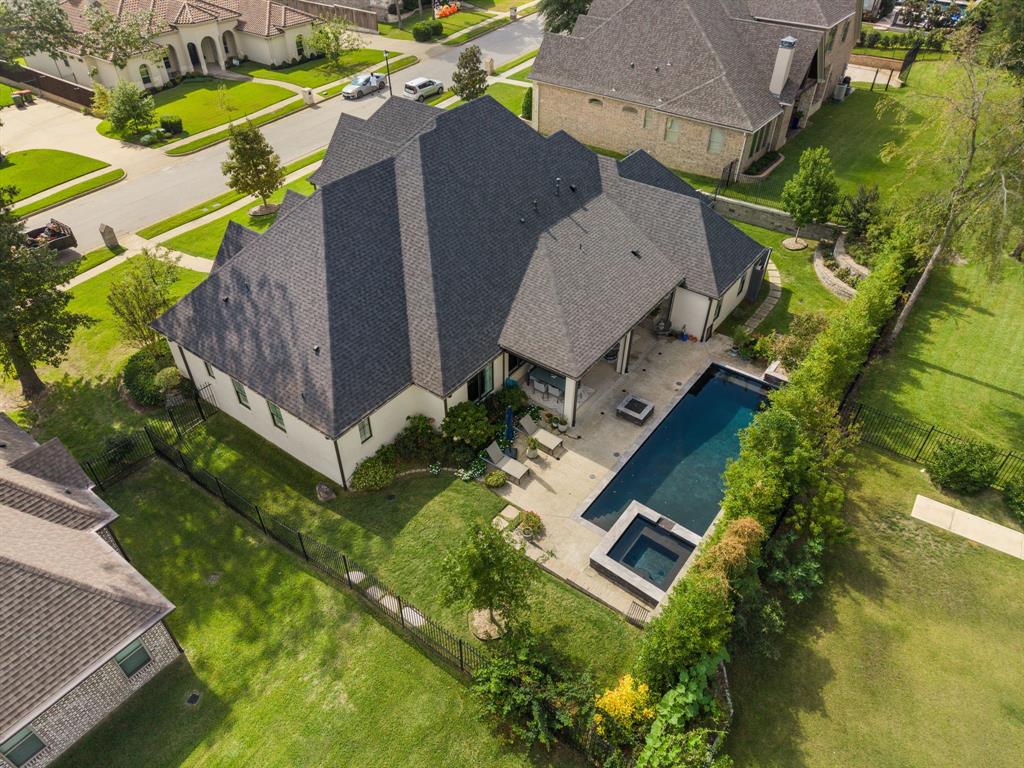 Multi-faceted roofline, covered rear patio, inground pool, integrated spa, and fenced backyard with manicured lawn