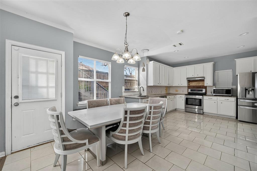 Kitchen featuring white cabinetry, stainless steel appliances, tile flooring, and a multi-arm chandelier