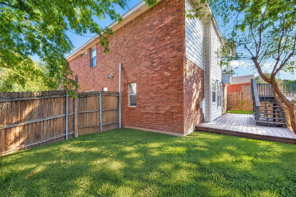 Exterior featuring red brick masonry, horizontal siding, wood-finish deck, and wood privacy fencing