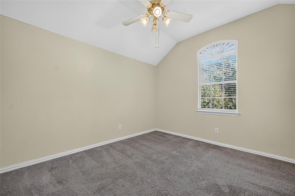 Vaulted ceilings, neutral wall tones, wall-to-wall carpeting, and an arched window with an integrated fan light fixture