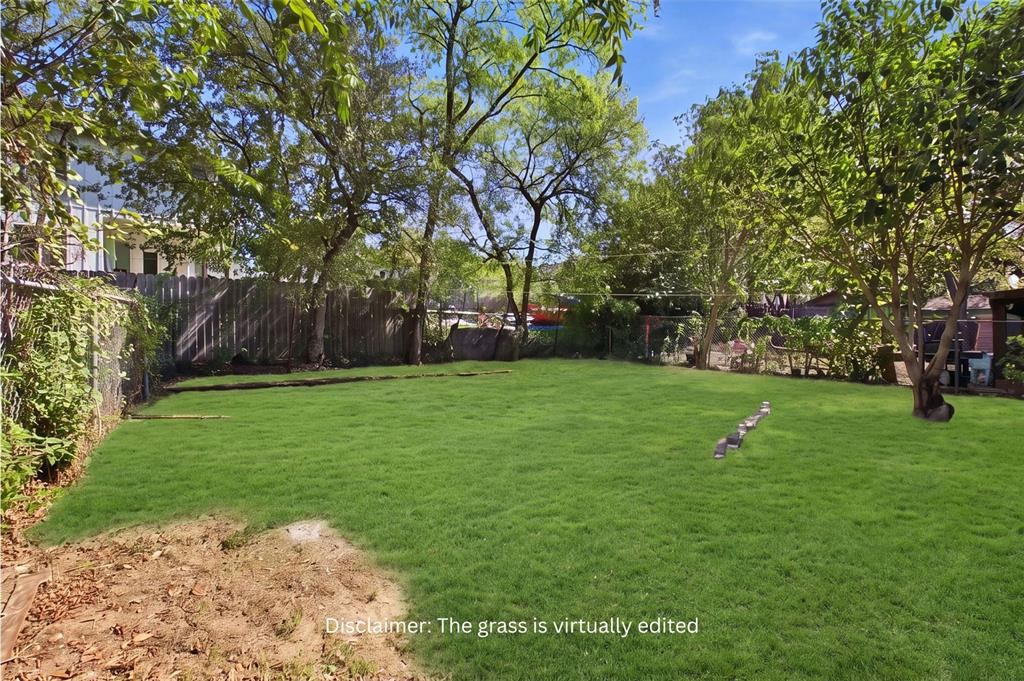 Expansive backyard featuring a fenced perimeter, mature trees, and open lawn space