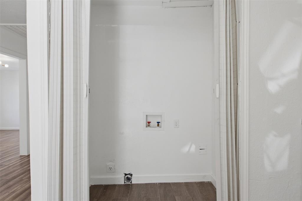 Laundry closet featuring vertical bifold doors, recessed water hookups, and electrical power outlets