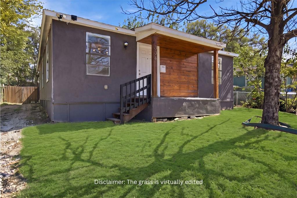 Exterior featuring stucco siding, a covered porch with wood-plank wall cladding, and a wood staircase with black metal railings