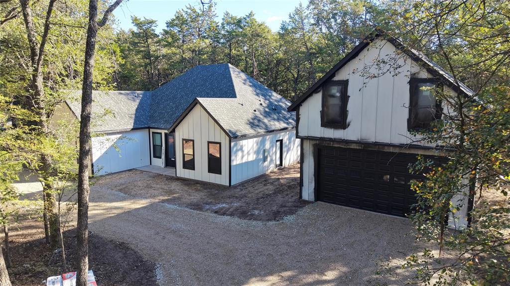 View of circular driveway, home and detached garage.