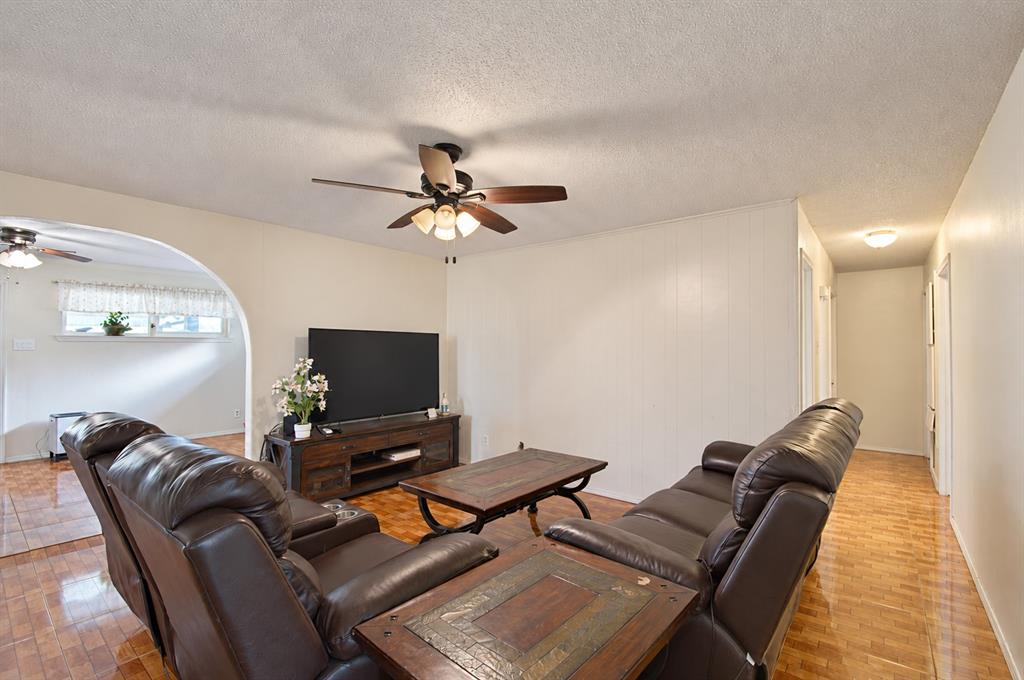 Interior space featuring arched architectural detailing, tile flooring, and a ceiling-mounted fan with integrated light fixture