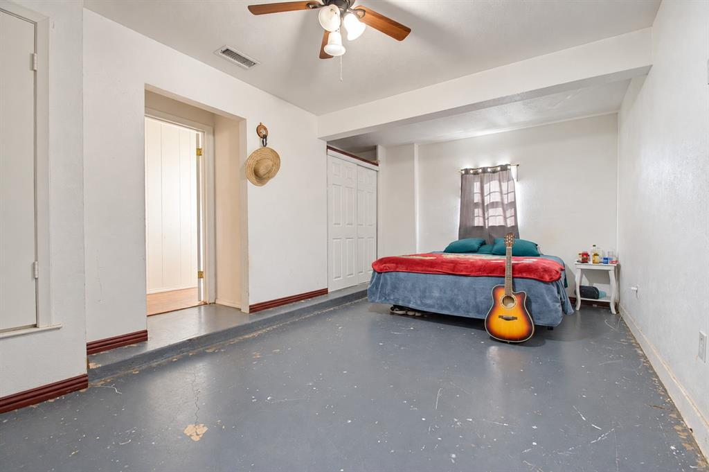 Multi-level room featuring painted concrete flooring, bi-fold closet doors, and a ceiling fan with integrated lighting