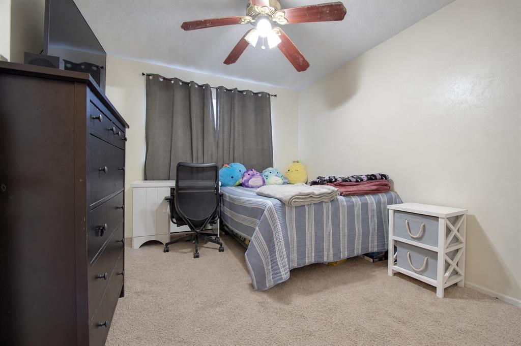 Bedroom featuring carpeted flooring and a multi-blade ceiling fan with integrated lighting