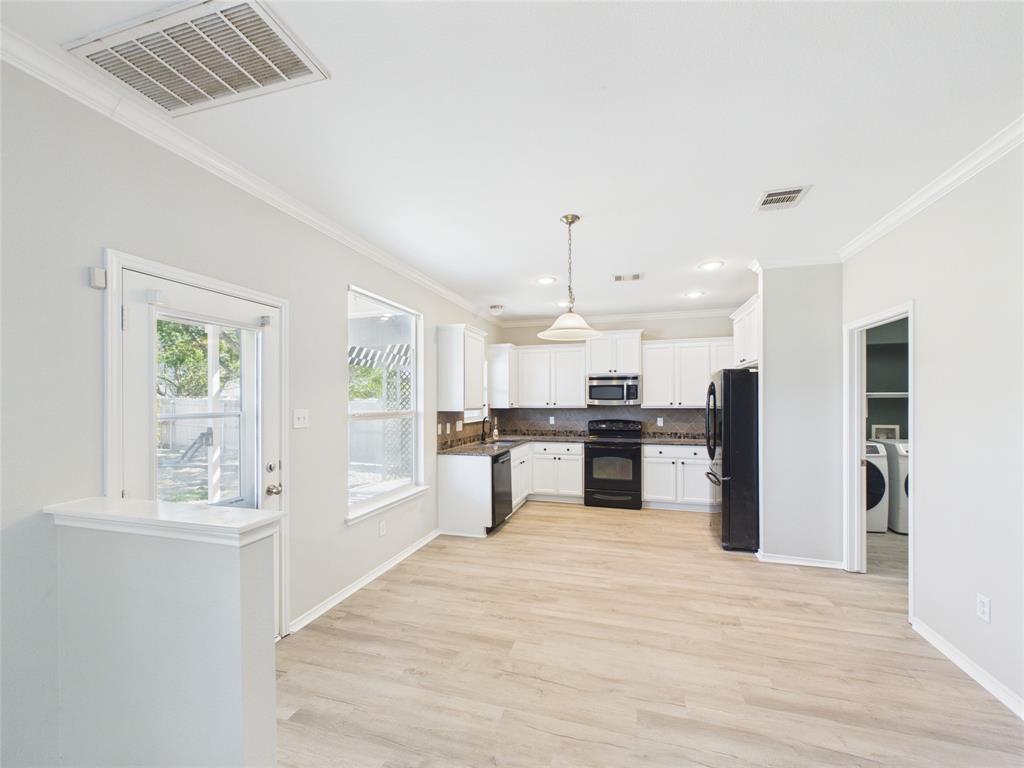 Kitchen featuring white cabinetry, wood-finish flooring, recessed lighting, and a pendant light fixture Kitchen featuring white cabinetry, wood-finish flooring, recessed lighting, and a pendant light fixture