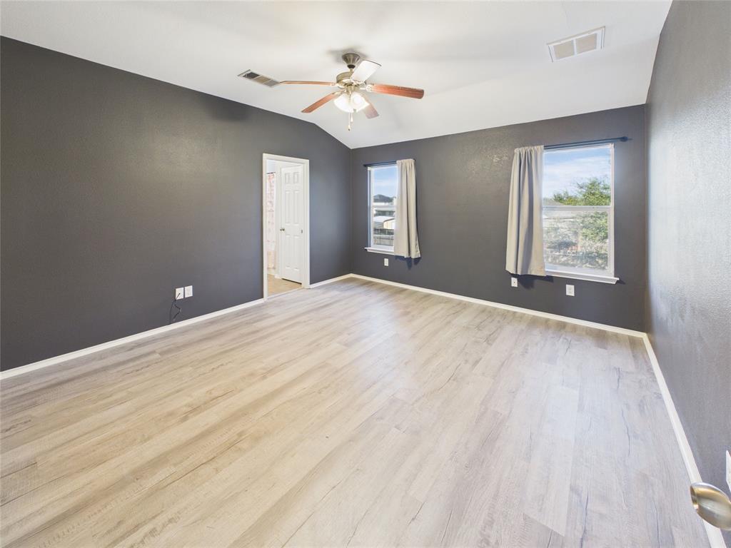 Upstairs Primary Bedroom Vaulted ceilings, wood-finish flooring, and a central ceiling fan