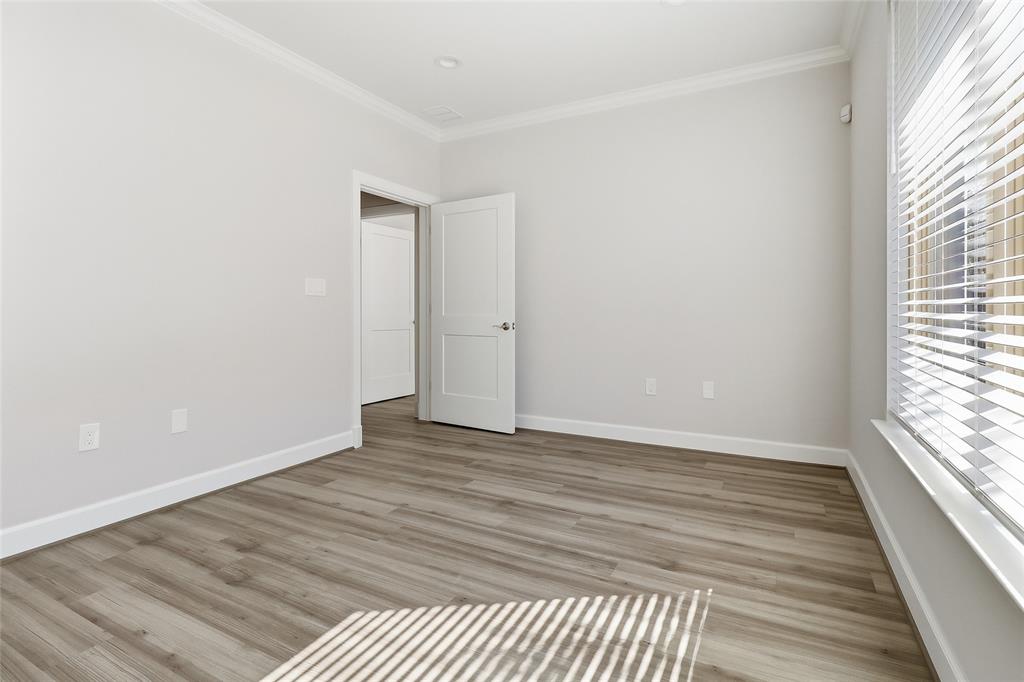 Wood-finish flooring, neutral wall tones, recessed lighting, crown molding, and two-panel interior doors