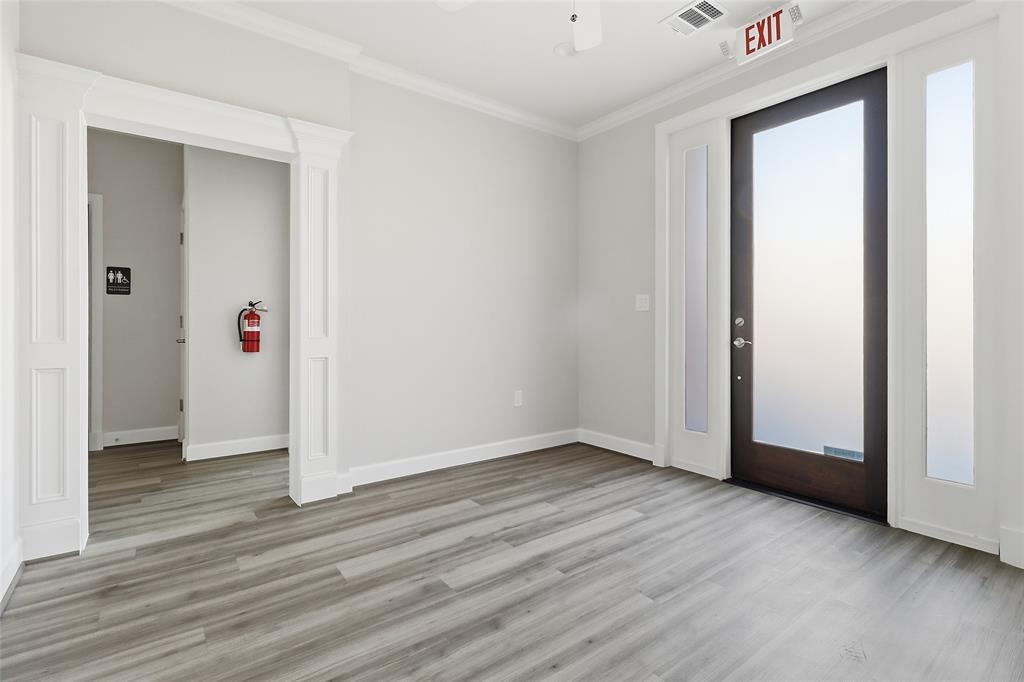 Wood-finish flooring, full-lite entry door with sidelights, crown molding, and architectural door casing Wood-finish flooring, full-lite entry door with sidelights, crown molding, and architectural door casing