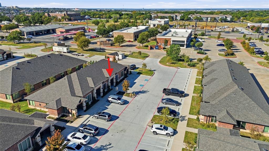 Commercial building featuring brick and masonry exterior, architectural shingle roofing, and dedicated concrete surface parking Commercial building featuring brick and masonry exterior, architectural shingle roofing, and dedicated concrete surface parking