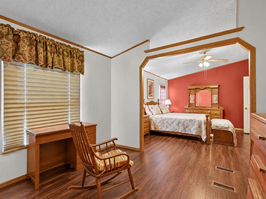 Wood-finish flooring, vaulted ceilings, and architectural pass-through with custom wood trim