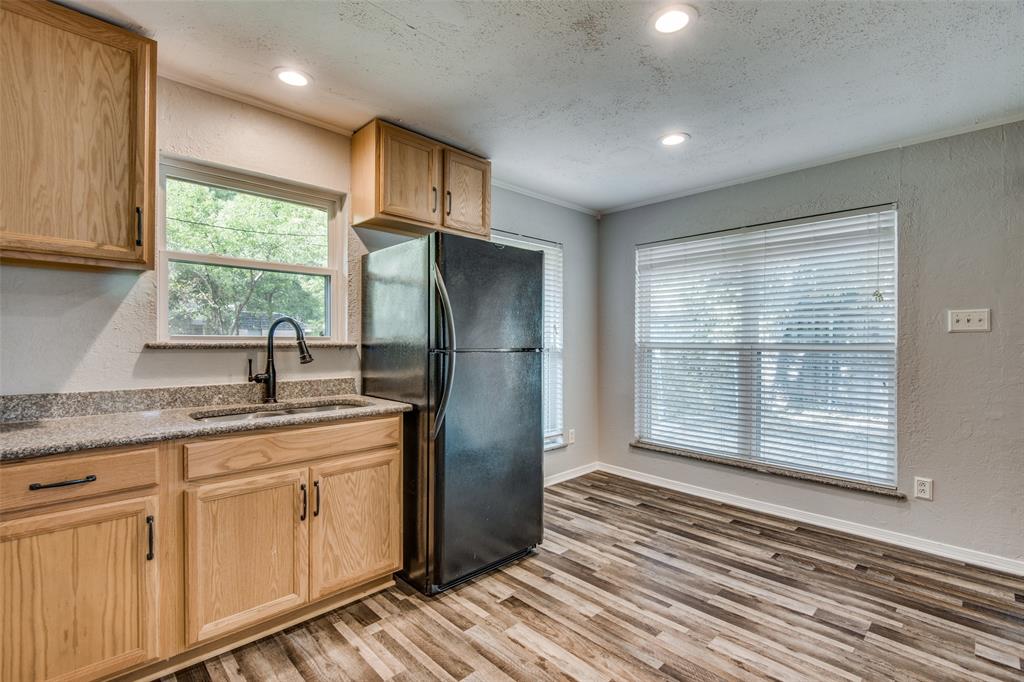 Kitchen featuring light wood-finish cabinetry, stone-texture countertops, wood-finish flooring, a high-arc faucet, and recessed lighting Kitchen featuring light wood-finish cabinetry, stone-texture countertops, wood-finish flooring, a high-arc faucet, and recessed lighting