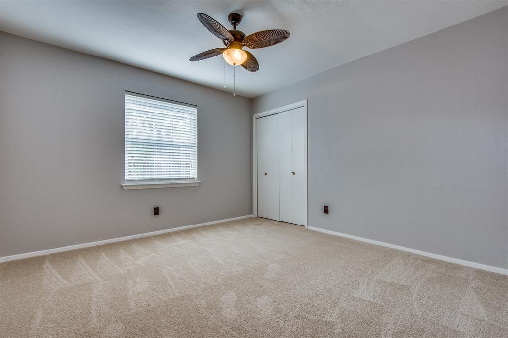 Neutral interior featuring wall-to-wall carpeting, a multi-blade ceiling fan with integrated lighting, and a bi-fold closet Neutral interior featuring wall-to-wall carpeting, a multi-blade ceiling fan with integrated lighting, and a bi-fold closet