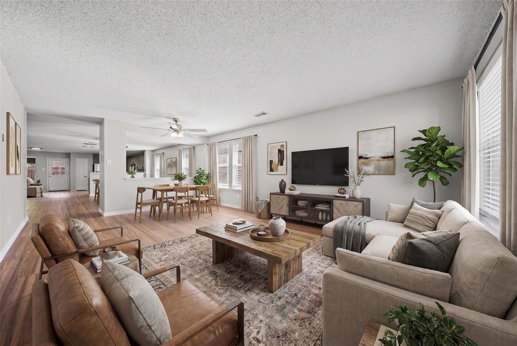 Open-concept interior featuring wood-finish flooring, a neutral color palette, and a ceiling-mounted light fixture with integrated fan Open-concept interior featuring wood-finish flooring, a neutral color palette, and a ceiling-mounted light fixture with integrated fan