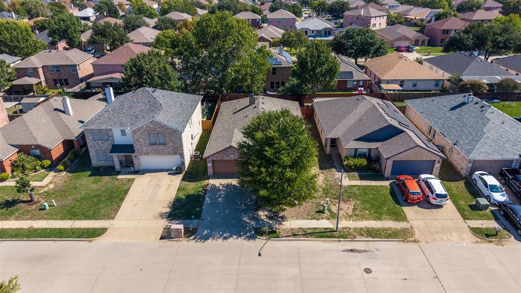 Single-story brick residence featuring a multi-gable roofline, attached two-car garage, concrete driveway, and mature landscaping