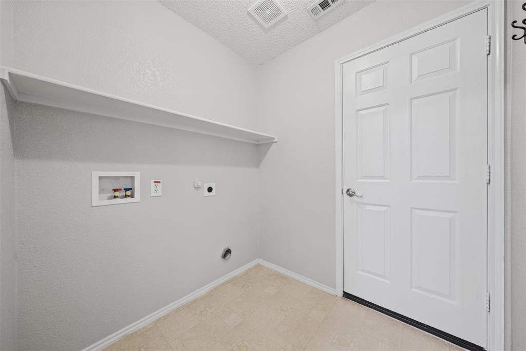 Utility space featuring a six-panel door, built-in shelving, and dedicated hookups for laundry appliances