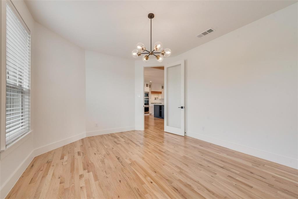 Room featuring wood-finish flooring, multi-light globe chandelier, and frosted glass panel door