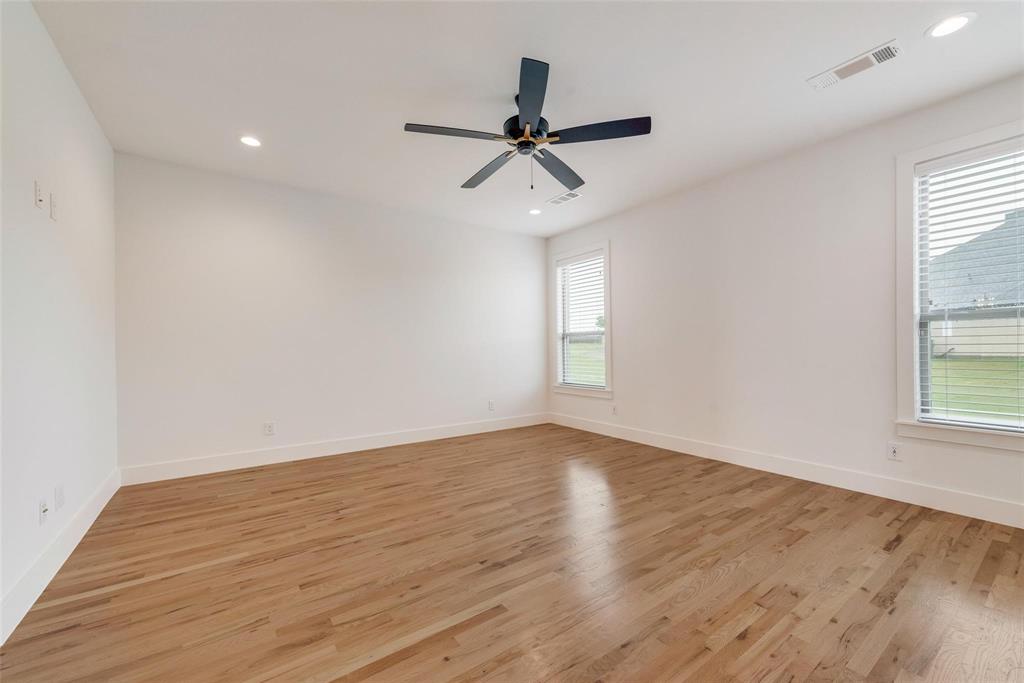 Neutral interior featuring wood-finish flooring, recessed lighting, and a dark-finish ceiling fan