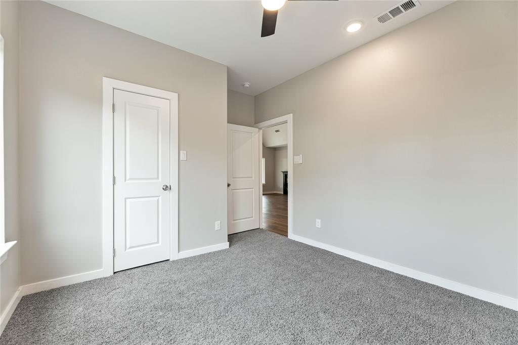 Neutral-toned interior space featuring wall-to-wall carpeting, two-panel interior doors, recessed lighting, and a ceiling fan