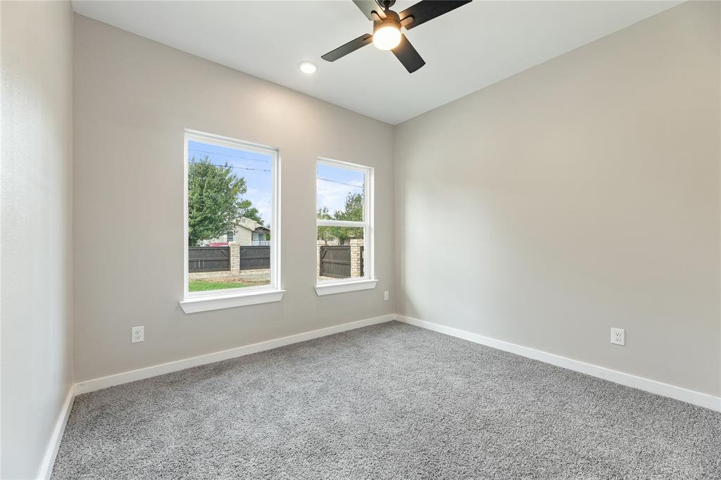 Neutral interior walls, plush carpeting, dual windows, recessed lighting, and a modern ceiling fan with integrated light fixture