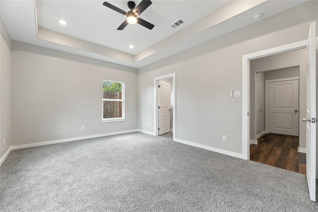 Tray ceiling with recessed lighting, integrated ceiling fan, neutral wall-to-wall carpeting, and interior panel doors